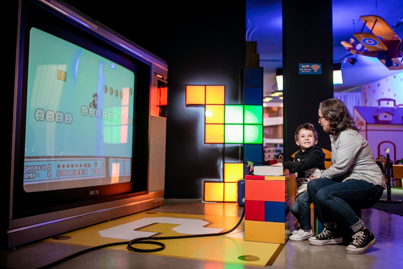 Televisão gigante com consoles clássicos de videogame no Big Land