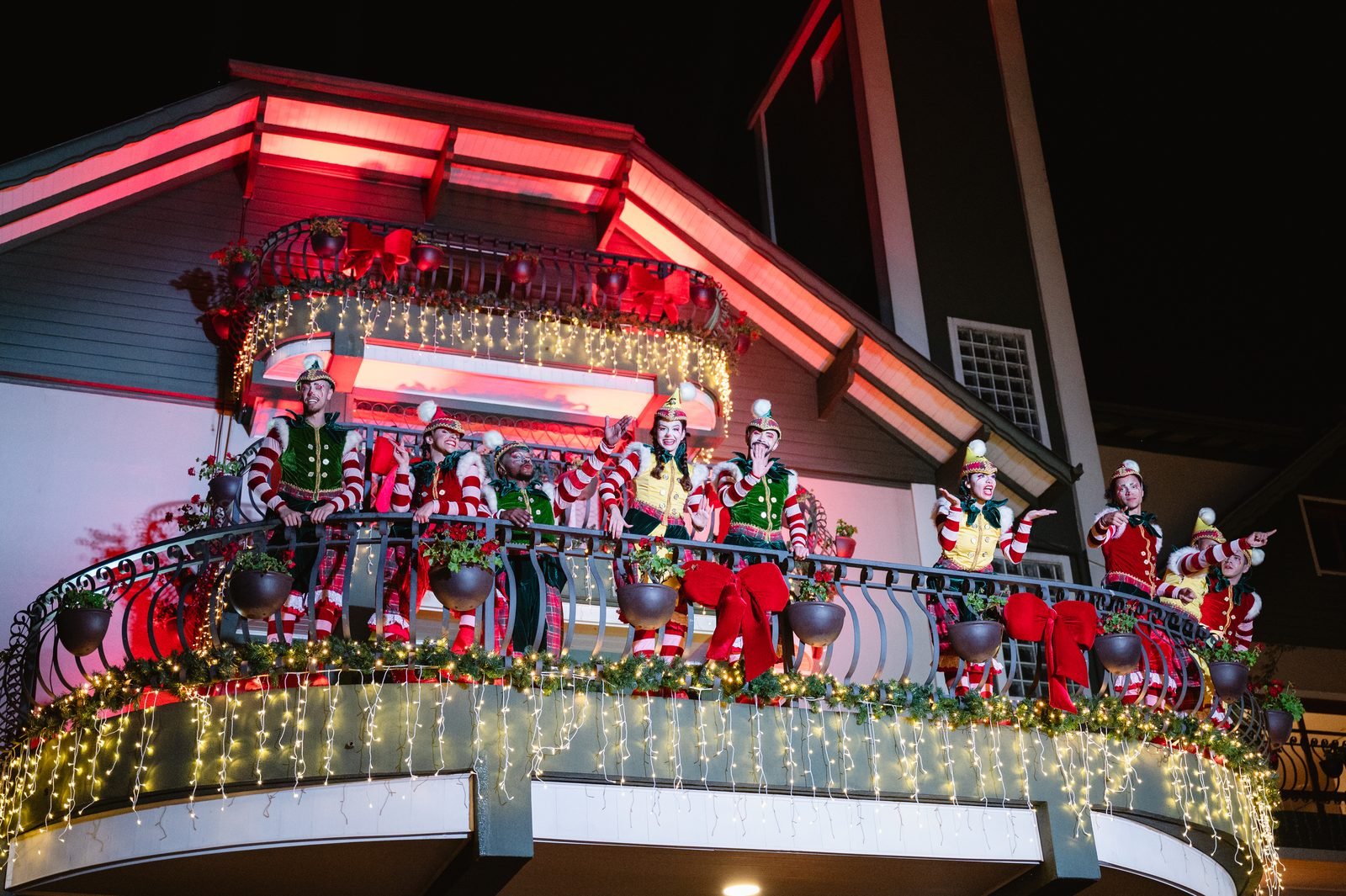 Artistas vestidos de duendes em sacada decorada de uma casa